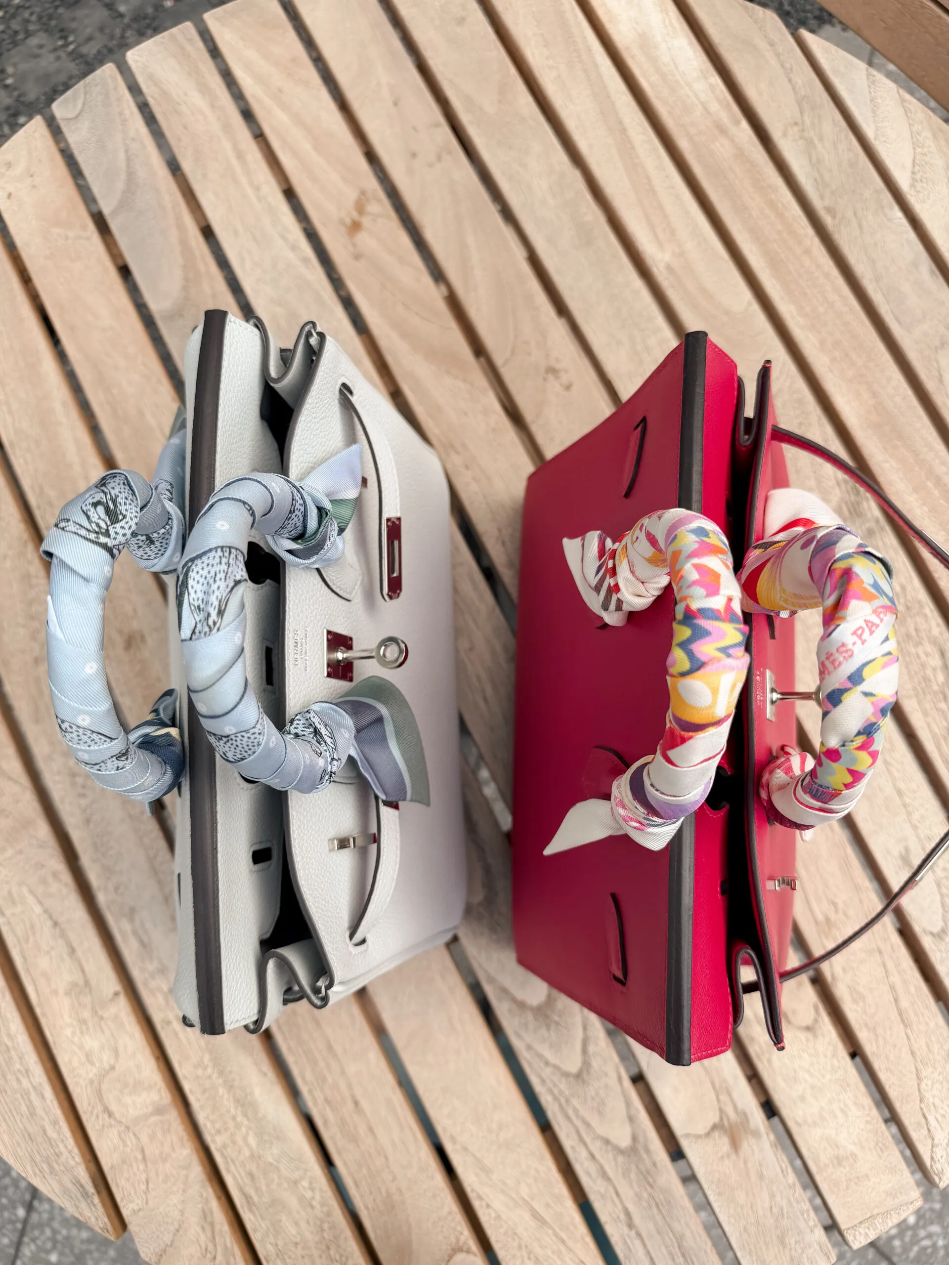 Overhead view of both Birkins open, showing twilly-wrapped handles and the Hermès Paris stamp