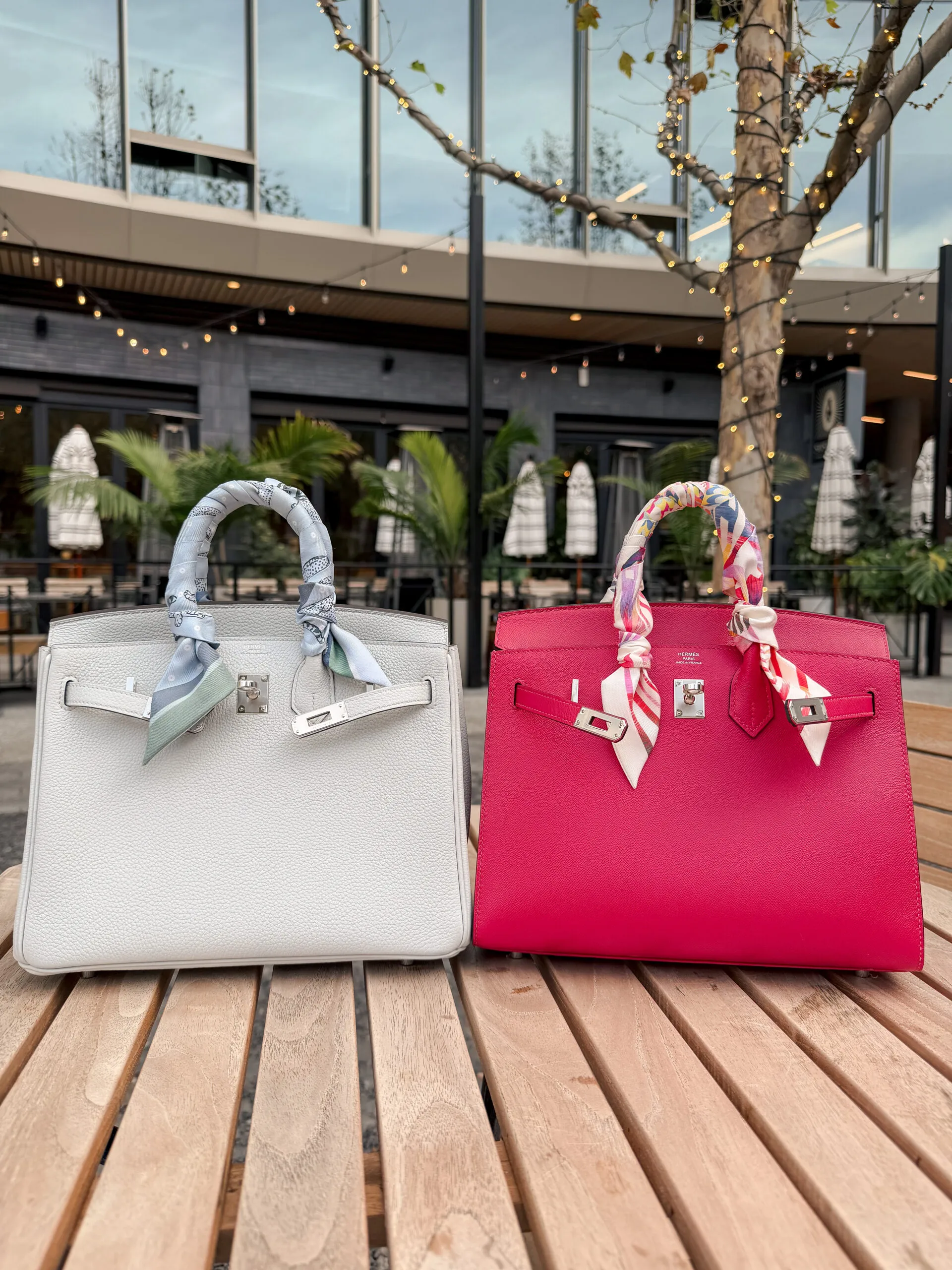 White Retourne and rose Sellier Birkins photographed together, silk twillys tied around both handles