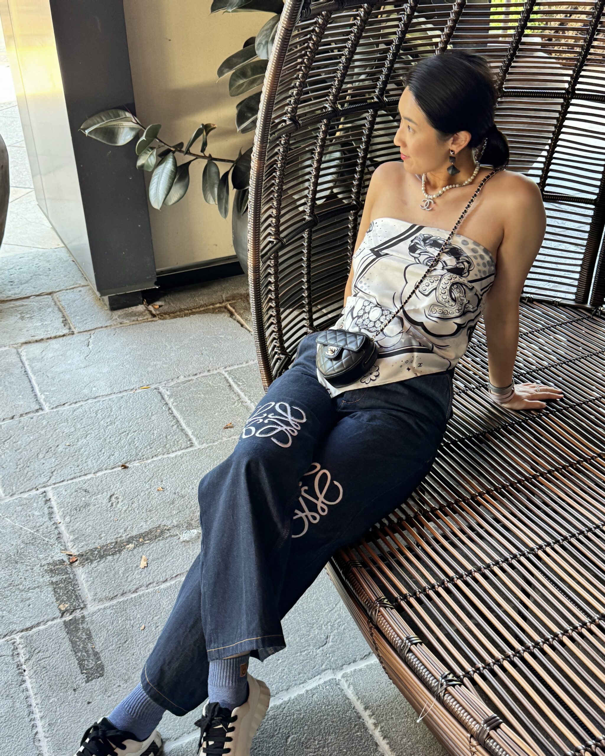 Lily wearing a casual luxury outfit with a scarf styled as a top and a Chanel crossbody bag in a relaxed setting
